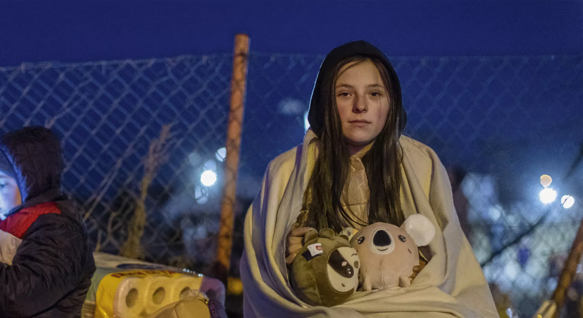 Kein Raum für Flüchtlinge: Mädchen aus der Ukraine sitzt eingehüllt in eine Decke in der Kälte