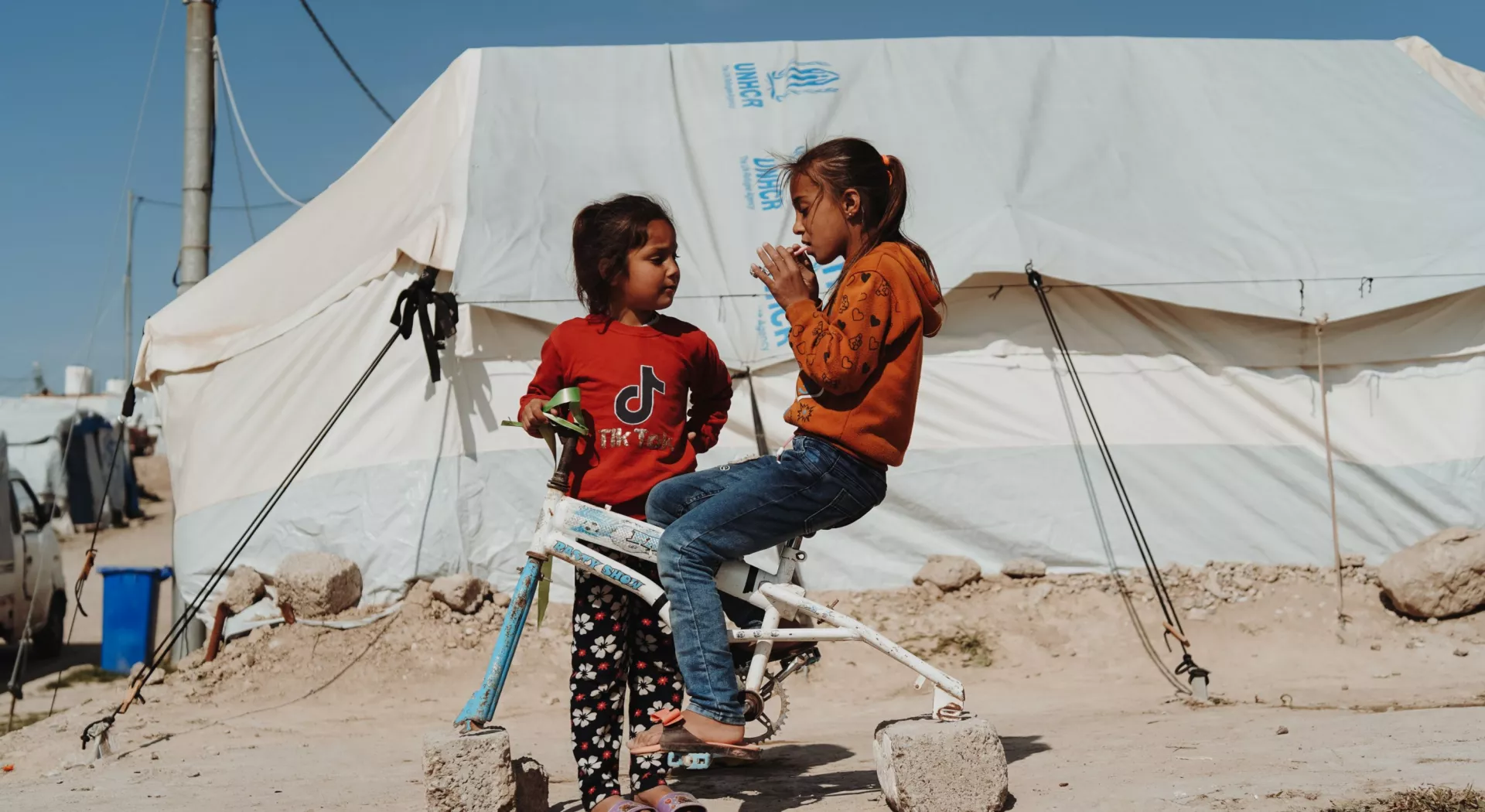 Flüchtlingskinder: Zwei Mädchen vor einem Flüchtlingszelt im Irak