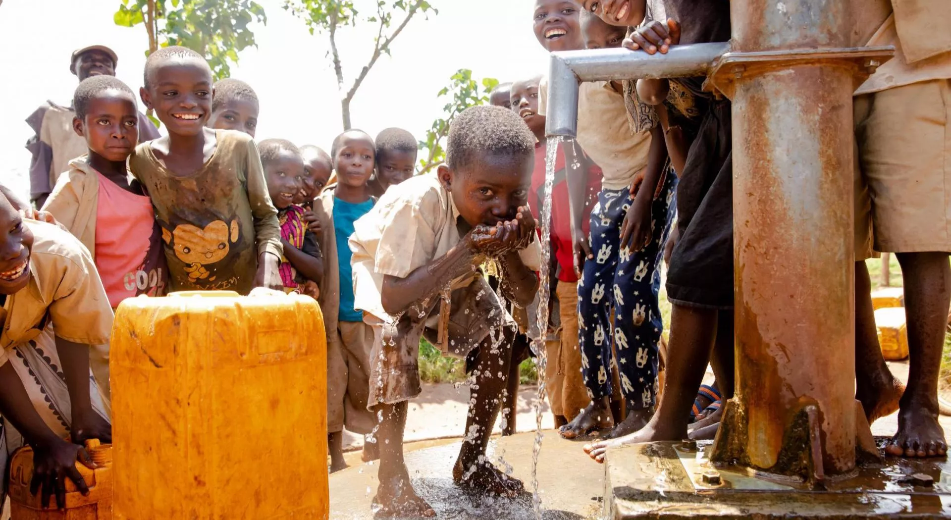 Burundi: Junge schöpft Wasser von einer neuen Wasserpumpe