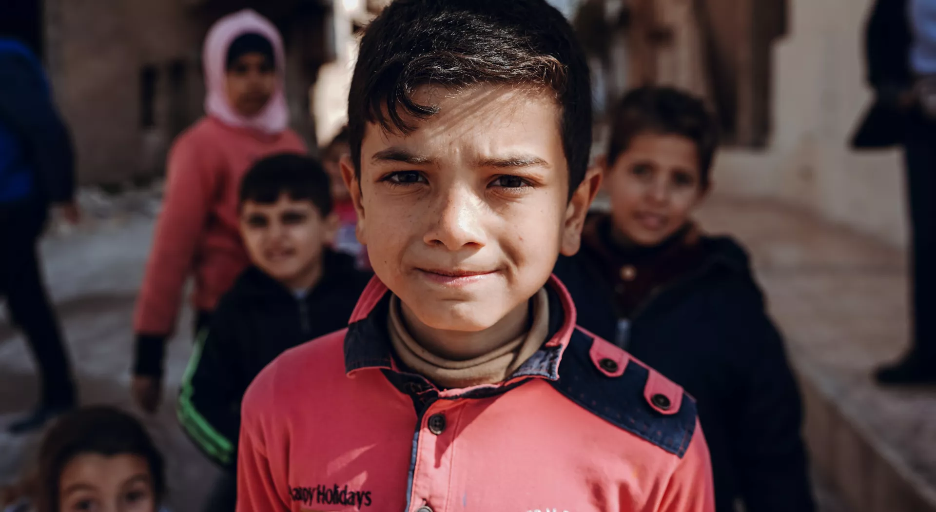 Nicht allein: Kleiner Junge Hamza aus Syrien vor weiteren syrischen Kindern