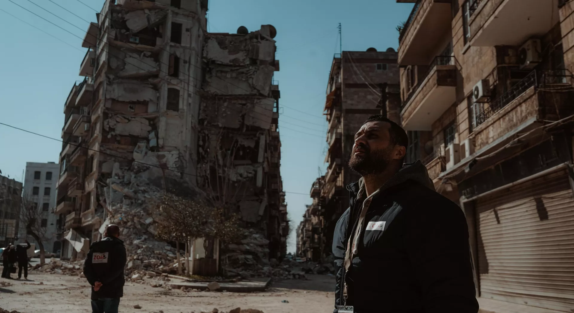 Erdbebenopfer in Syrien: Syrischer Mann steht vor zerfallenen Gebäuden 