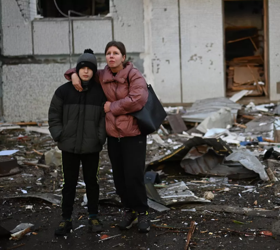 Nothilfe in der Ukraine: Kinder stehen vor einem zerstörten Haus