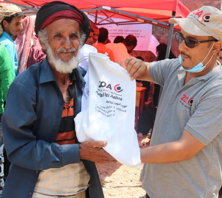 Jahresbericht: Mann im Jemen erhält Lebensmittel von ZOA Mitarbeiter