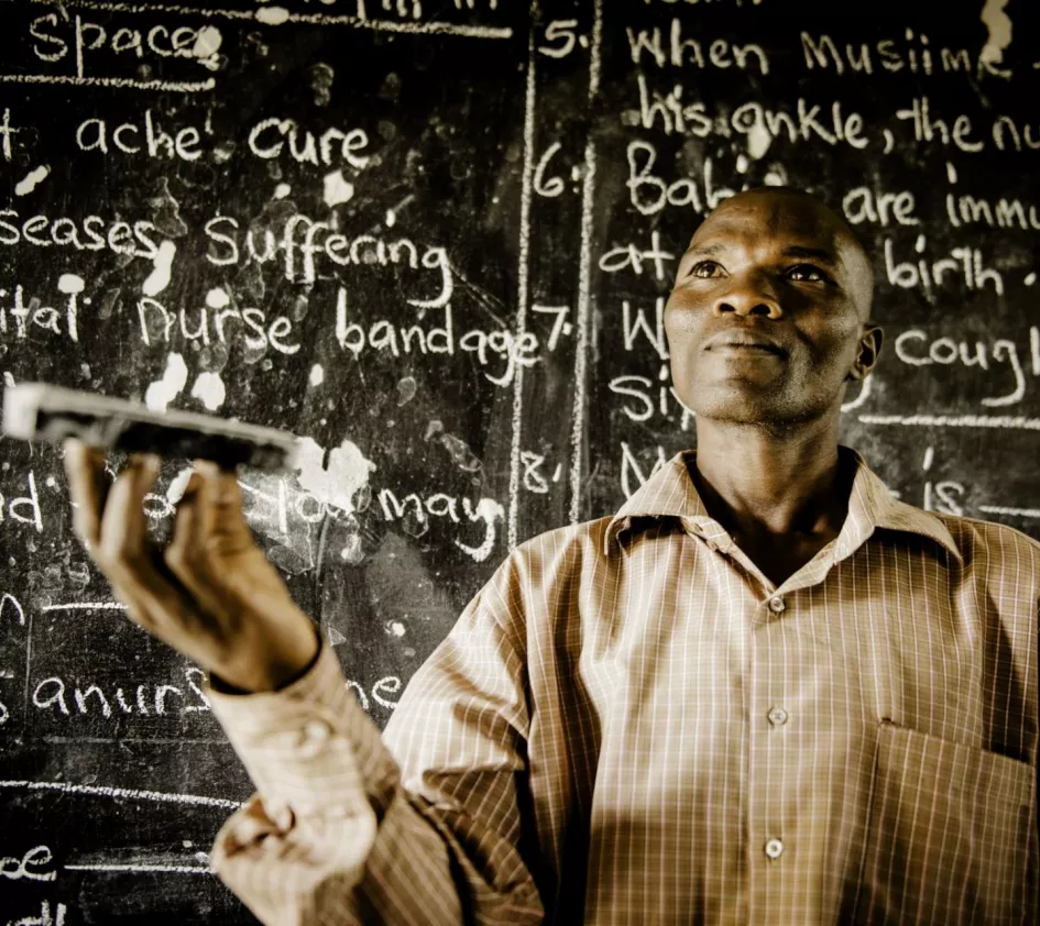 Weshalb ZOA in Bildung investiert: dunkelhäutiger Mann vor einer vollgeschriebenen Tafel