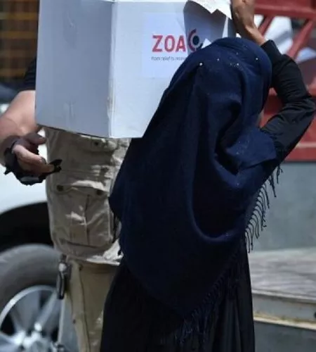 Syrien: Einheimische Frau trägt Essenspaket von ZOA