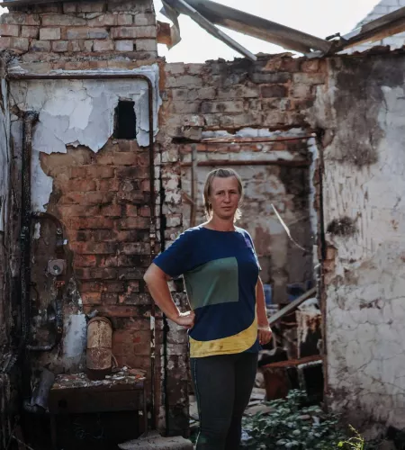 Ukraine: Eine Ukrainerin steht in ihrem zerstörten Haus