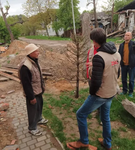 Aktuelle Lage in der Ukraine: Hielke spricht mit einem einheimischen Mann, von dessen Haus nur noch wenig übrig ist