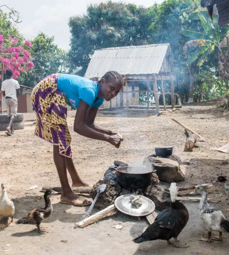 Leben auf der Flucht: Eine Frau kocht auf offenem Feuer