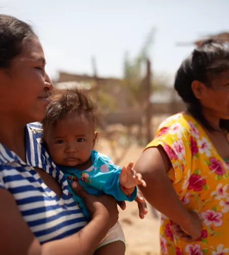 Was ist los in Kolumbien: Kolumbianischer Frauen halten ihr Kleinkind im Arm