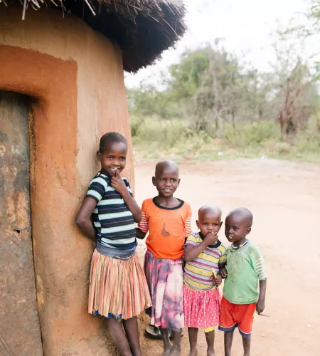 Weltflüchtlingstag: Ugandische Kinder vor einem Haus 