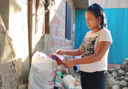 Müll sammeln, um zu überleben: Nathaly aus Kolumbien vor Müllsäcken