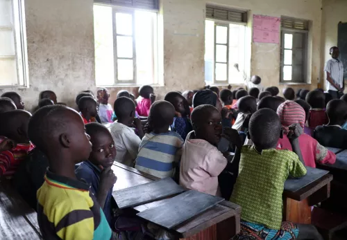 Back to School: Kinder in einem vollbesetzten Klassenzimmer in Uganda