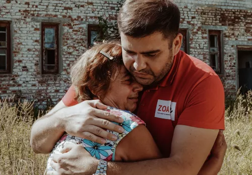 Ein ZOA-Mitarbeiter umarmt eine ukrainische Frau. 
