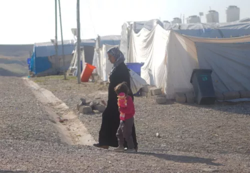 Was müssen Flüchtlinge zurücklassen: Frau mit Kind vor einem Flüchtlingscamp