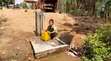 Myanmar: Junge schöpft Wasser an einer Wasserpumpe